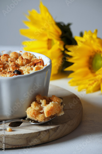 Apples with crumble and cinnamon. Autumn dessert. A hot dessert for cold days. Yellow sunflowers.