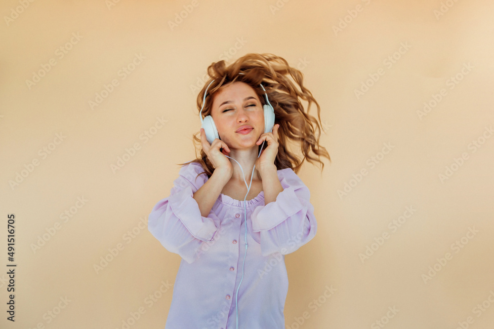 A charming girl with headphones dancing with her hair and eyes closed. A charming girl with headphones dancing with her hair and eyes closed.