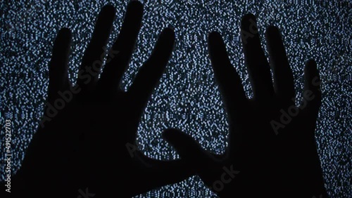 Silhouettes of hands touching an old television screen with white noise. Static TV noise, analog signal. Bad signal. Vintage screen. Monochrome. TV effects, artifacts, bad interference. Retro 80s, 90s photo