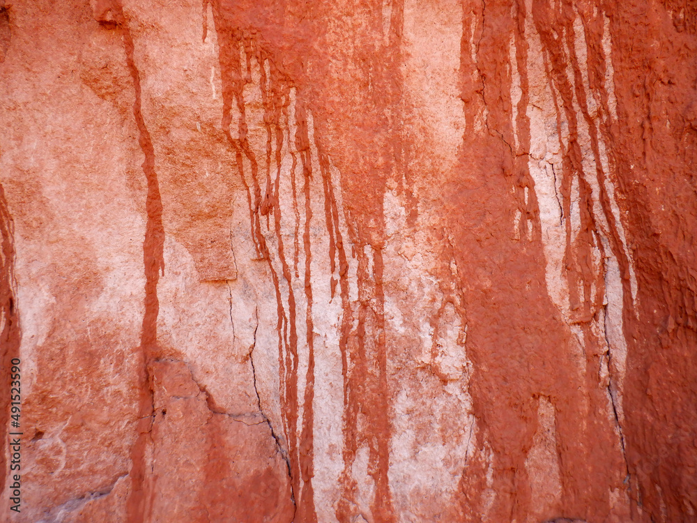 Dripping red, pink and white patterns on a arroyo wall in the Bears Ears wilderness area of Southern
