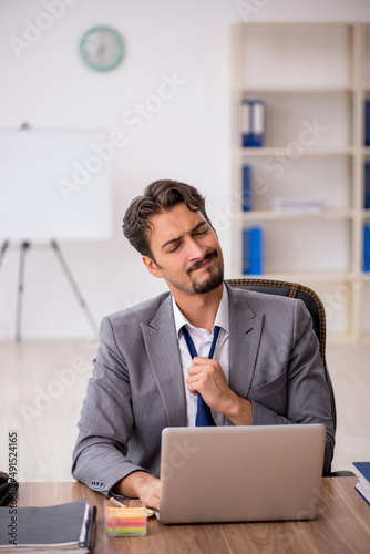 Young male employee sitting in the office