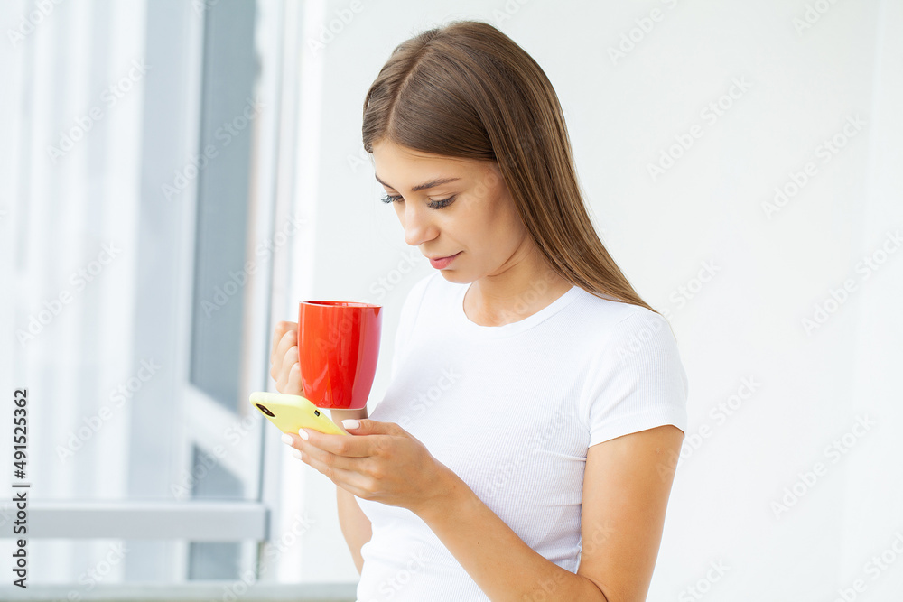 A young brunette woman looks at the mobile phone screen A young brunette woman looks at the mobile phone screen