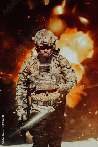 Принти на полотні A bearded soldier in a special forces uniform walks through an abandoned building after a successful mission