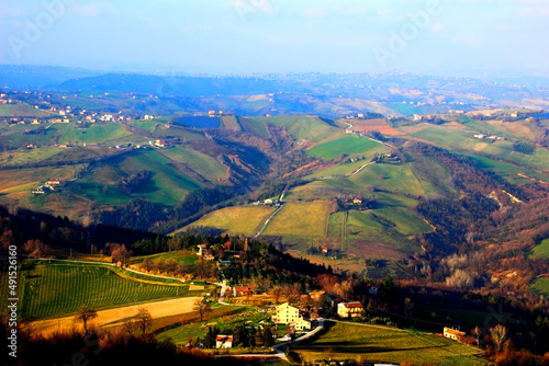 Amazing view from above at Marche hills covered by forests and fields with rare houses during a sunny winter day in Penna San Giovanni