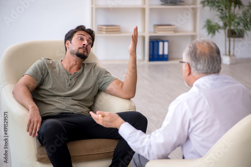 Young man visiting old psychologist