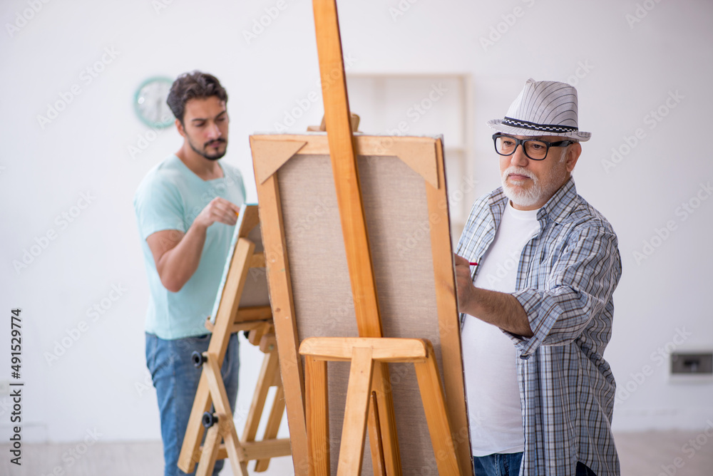Two male painters enjoying painting at home