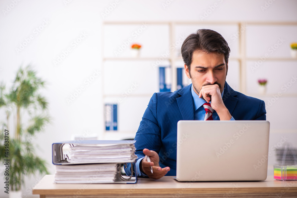 Young male employee sitting at workplace Young male employee sitting at workplace