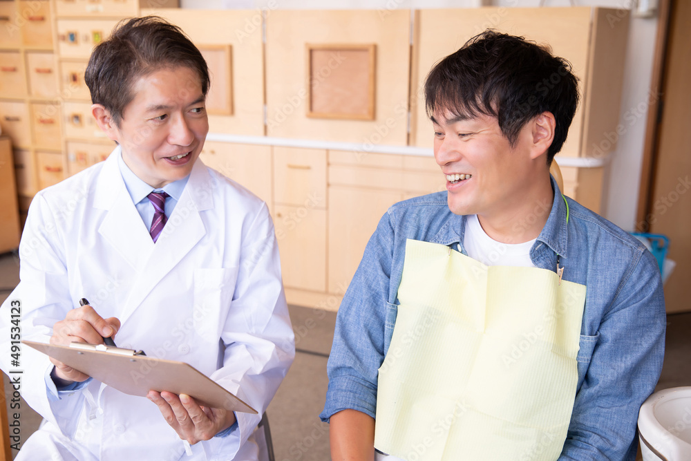 Obraz premium 歯医者と男性患者（タブレット）