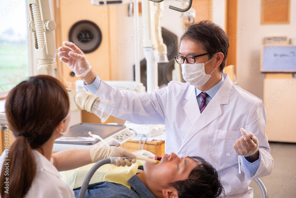 Obraz premium 治療する歯科医師と歯科衛生士 