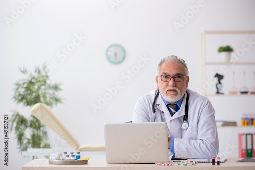 Old male doctor pharmacist working at the lab