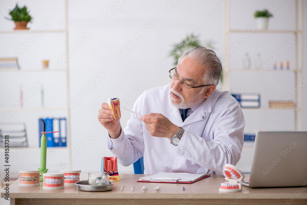 Old male doctor dentist working in the clinic Old male doctor dentist working in the clinic