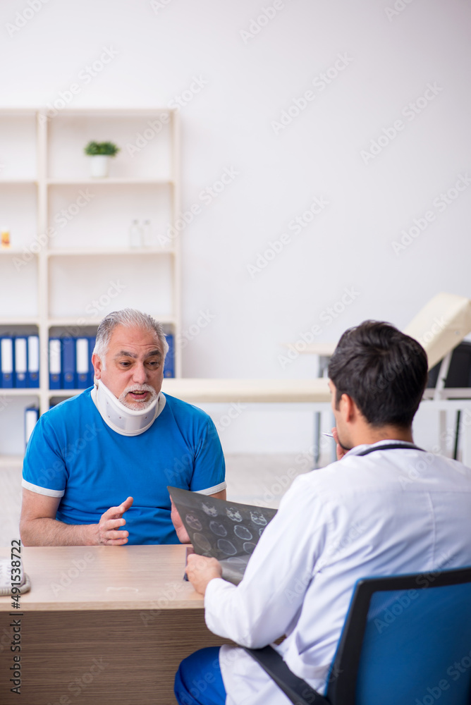 Obraz premium Old male patient visiting young male doctor radiologist
