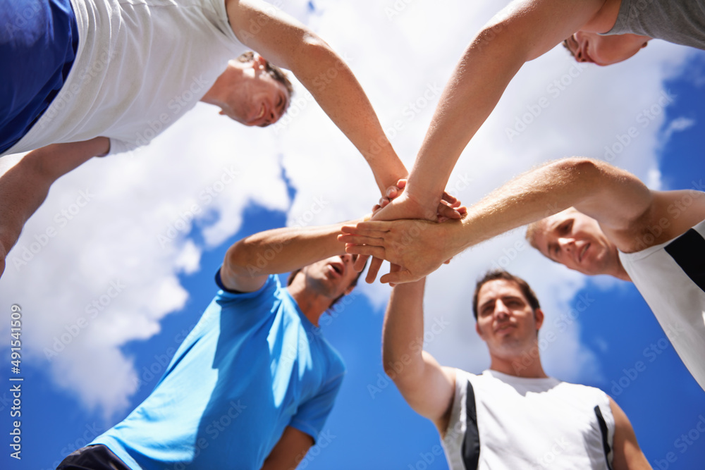 Lets do this, team. Shot of a group of young sportsmen piling their hands while standing in a huddle. Lets do this, team. Shot of a group of young sportsmen piling their hands while standing in a huddle.