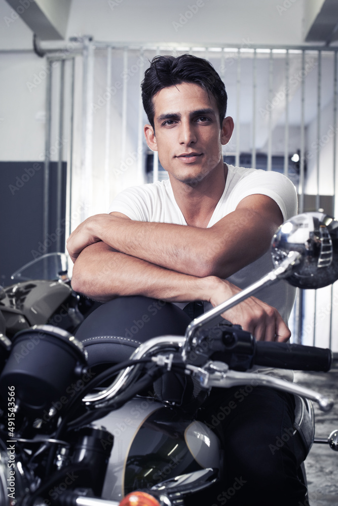 Want to go for a joyride. A handsome young man sitting on his motorcycle. Want to go for a joyride. A handsome young man sitting on his motorcycle.