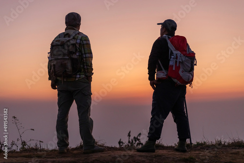 Silhouette Hiking friends with backpack looking enjoying sunset view