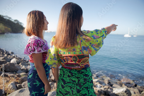 two women guna standing on the beach photo