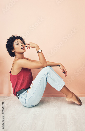Im a savage. Shot of a beautiful young woman striking a pose while sitting on the floor.