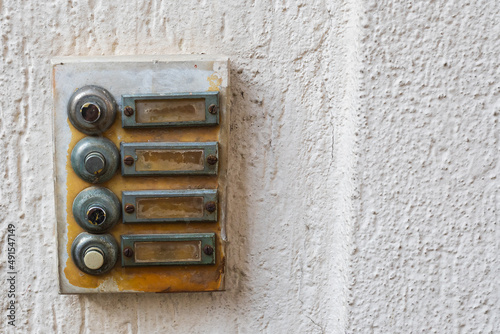 Close-up of an old metal plate on a house with bells