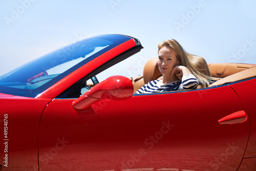 Symbol of success.... Shot of a young woman driving in a sports car.