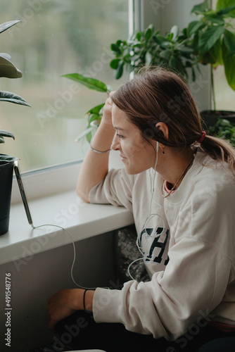 A young pretty woman in headphones communicates via video chat with mobile phone © Ekaterina