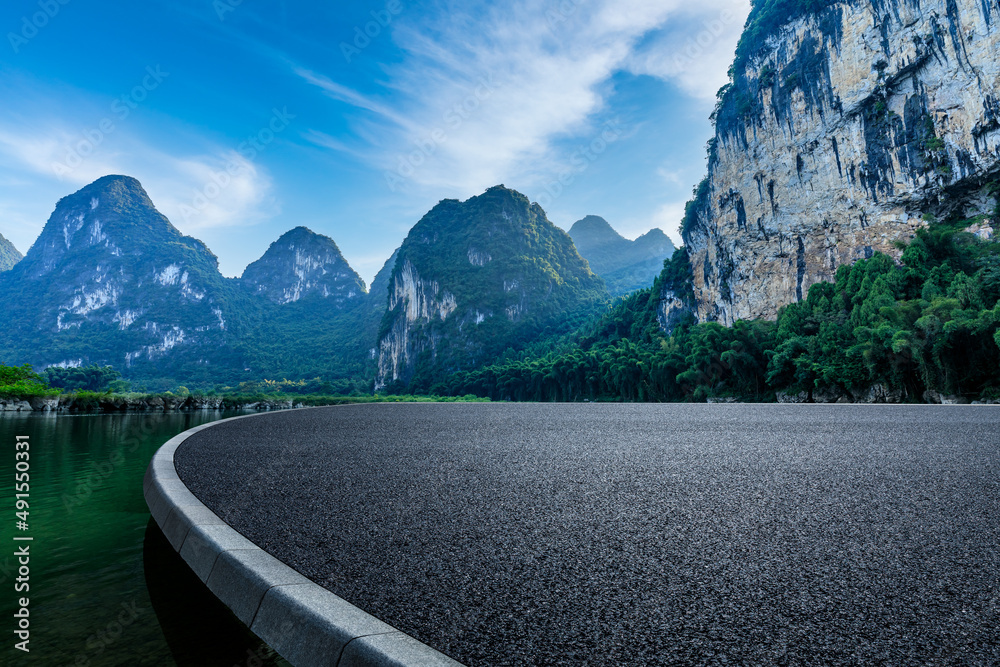 Asphalt road platform and mountain natural scenery under blue sky in summer. Road and mountain background.