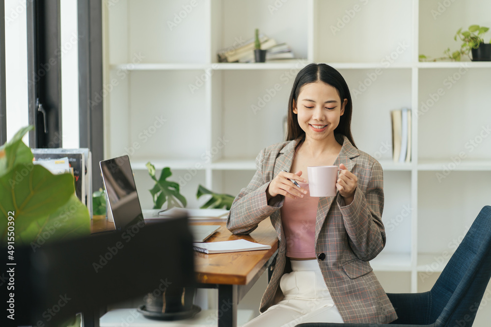Benefits of remote work. Dreamy lady enjoying coffee during work on laptop computer in city cafe, smiling and looking aside. Young freelancer having break while working online in internet Benefits of remote work. Dreamy lady enjoying coffee during work on laptop computer in city cafe, smiling and looking aside. Young freelancer having break while working online in internet