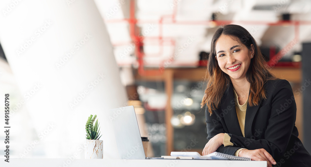 Young asian beautiful and charming businesswoman smiling and working on laptop computer at office. Young asian beautiful and charming businesswoman smiling and working on laptop computer at office.