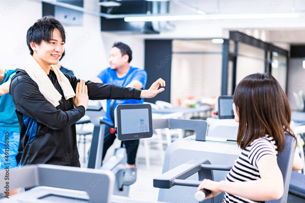 ジムでトレーナーの指導を受ける若い女性