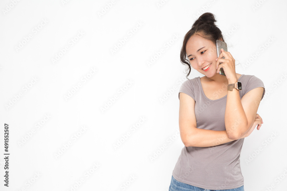 Beautiful Asian woman wearing grey casual shirt holding smartphone on white background and copy space. Cute Asian woman smiling and cheerful talk something on the phone for social media concept Beautiful Asian woman wearing grey casual shirt holding smartphone on white background and copy space. Cute Asian woman smiling and cheerful talk something on the phone for social media concept