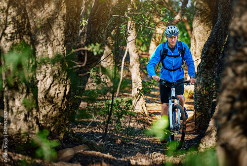 Forest fitness fanatic. Shot of a male cyclist riding along a mountain bike trail.