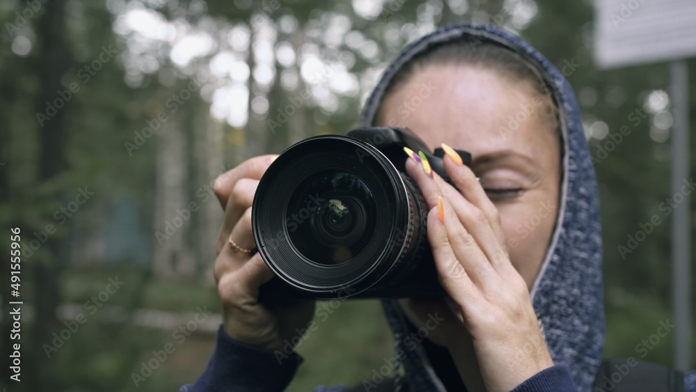 Traveler photographing scenic view in forest. One caucasian woman shooting close up look. Girl take photo video on dslr mirrorless camera. Professional photographer travel with backpack. Outdoor. Traveler photographing scenic view in forest. One caucasian woman shooting close up look. Girl take photo video on dslr mirrorless camera. Professional photographer travel with backpack. Outdoor.
