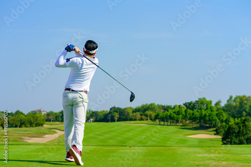 Man Golfer Hitting Ball with Club on Beatuiful Golf Course