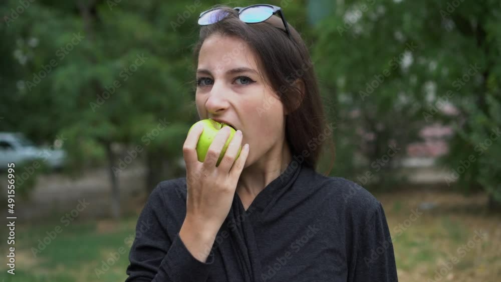Girl eats apple on street. Fruit is good food that is convenient to eat on the go. Girl eats apple on street. Fruit is good food that is convenient to eat on the go.
