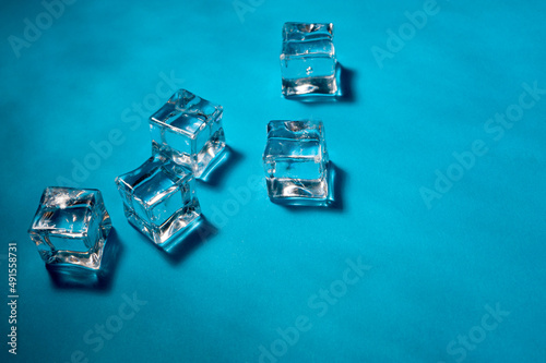Fototapeta Naklejka Na Ścianę i Meble -  Clear ice cubes for cooling drinks on a blue background.