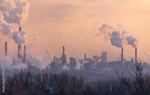 Smoke from the chimneys of a steel plant at sunset © schankz