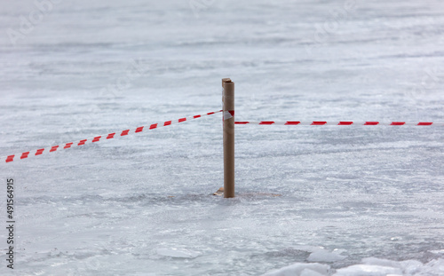 Restrictive tape on lake ice in winter.