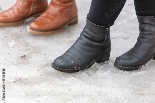 Women's legs in boots on the snow.