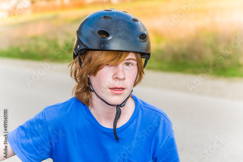 young boy is biking and wearing a helmet © travelview