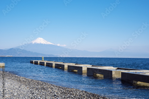 Fototapeta Naklejka Na Ścianę i Meble -  晴天の日の遠くに見える雪の富士山と砂浜から見える美しい景色
