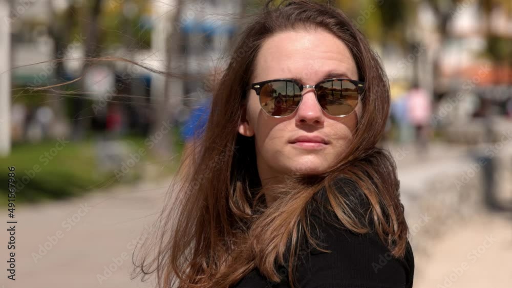 Young woman relaxes at the promenade of Miami Beach on a sunny day - travel photography