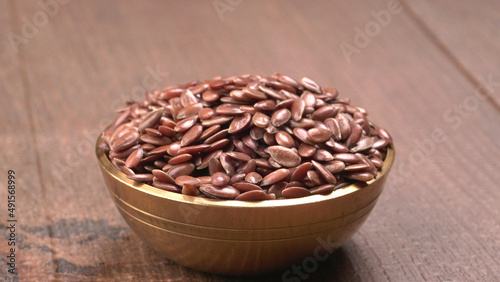 Brown flax seed or linseed on wooden background. Diet healthcare healthy food.
