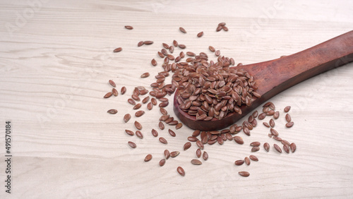 Brown flax seed or linseed on wooden background. Diet healthcare healthy food.