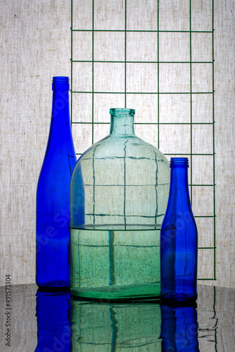 Still life with blue bottles and a jar with water photo