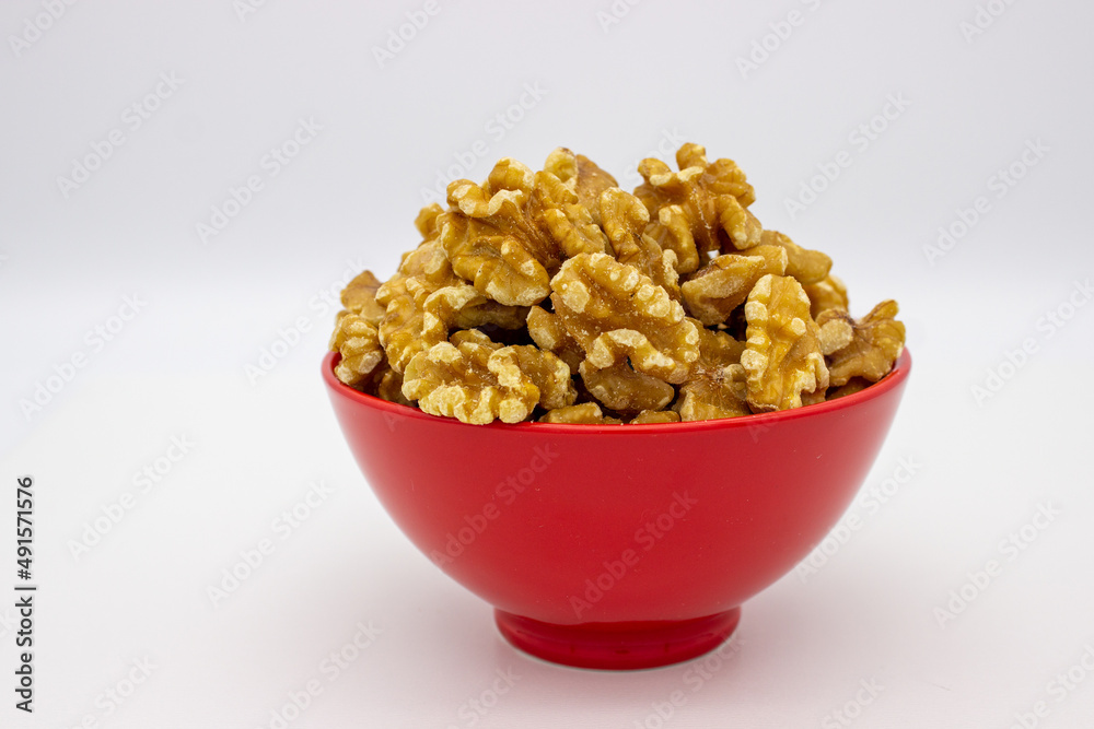 Peeled walnuts in red plate Peeled walnuts in red plate