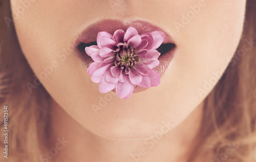Floral concepts. Closeup shot of a woman with a flower in her mouth.