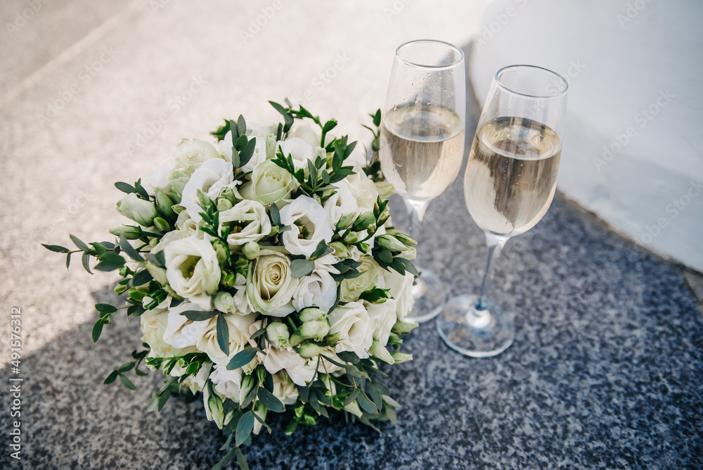 Glasses of champagne on a background of flowers Glasses of champagne on a background of flowers
