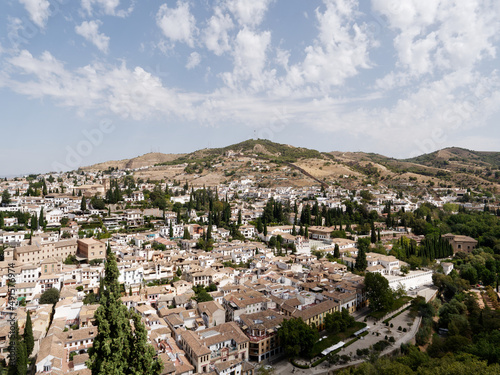 Panoramic view of the city of Granada in Spain. Old and multicultural town. Sunny day, blue sky and some clouds. Heritage Spain.  © stu.dio