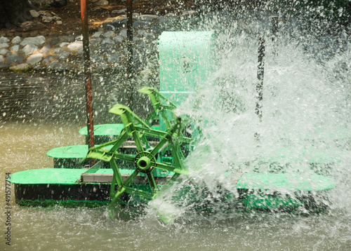 Motion image of water splashing by green farm water aeration system for Outdoor fish or shrimp farming pond. photo