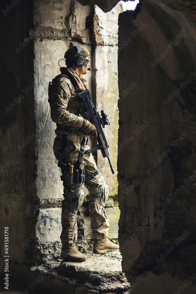 Guarding pose with heavily armed suit at border building . High quality photo