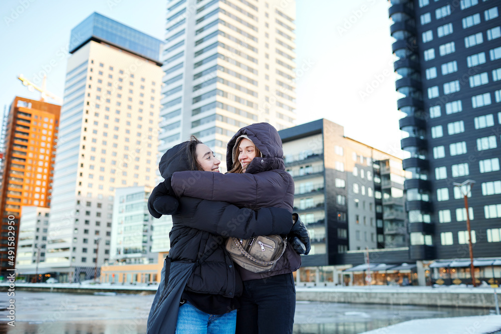Young female couple hugging in modern neighborhood Young female couple hugging in modern neighborhood